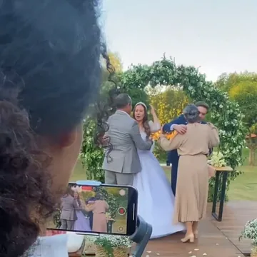 IMAGEN: miniatura redonda del paso 2 — grabando en plena fiesta, cámara hacia afuera